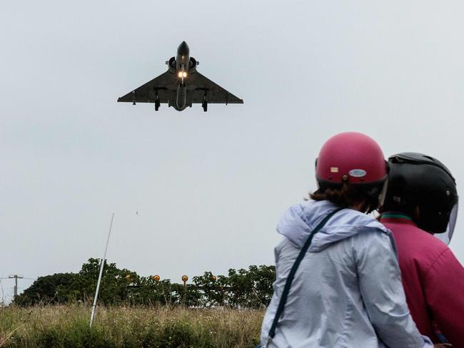 (FILES) Two people ride a motorcycle as a Taiwanese Air Force Mirage 2000 fighter jet approaches for landing at an air force base in Hsinchu in northern Taiwan on May 23, 2024. US Defence Secretary Lloyd Austin and his Chinese counterpart Dong Jun are expected to meet in person for the first time at the annual Shangri-La Dialogue, which starts in Singapore on May 31, 2024, as tensions over Taiwan and the South China Sea escalate. (Photo by Yasuyoshi CHIBA / AFP)