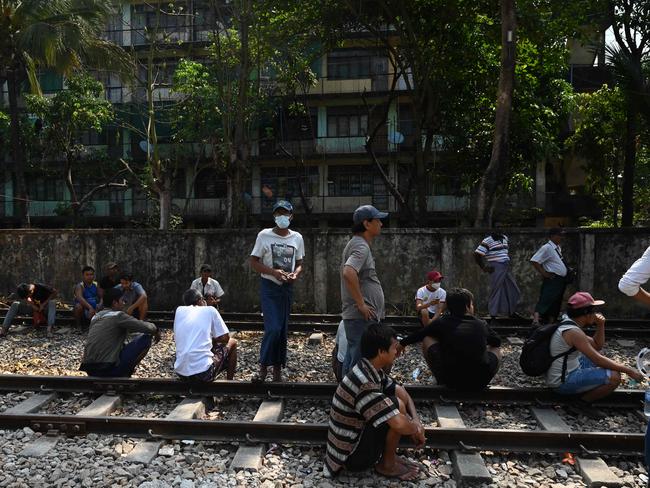 Railway staff gather by the train tracks as security forces arrive to arrest workers involved in the Civil Disobedience Movement, in protest over the military coup. Picture: AFP