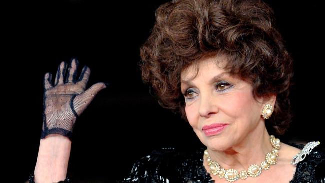Italian actress Gina Lollobrigida waves upon her arrival for the premiere of the documentary film 