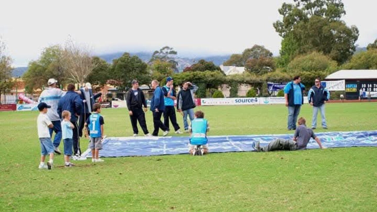 Mr Robinson (second from right) helping put together Sturt Football Club’s banner. Picture: Supplied