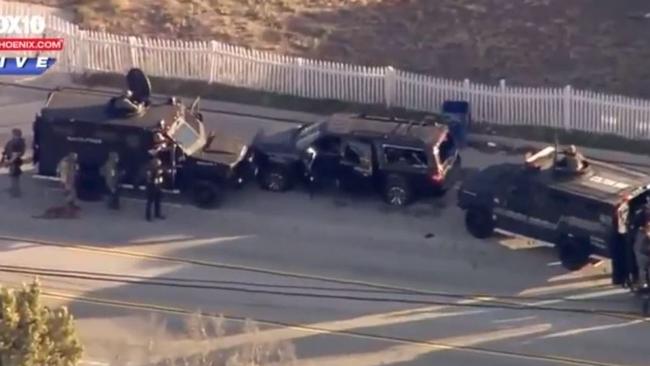 Shots fired... the black SUV (centre) was cornered by police.