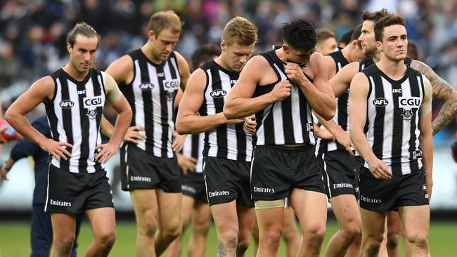 Collingwood players walk off the MCG after losing to Carlton.