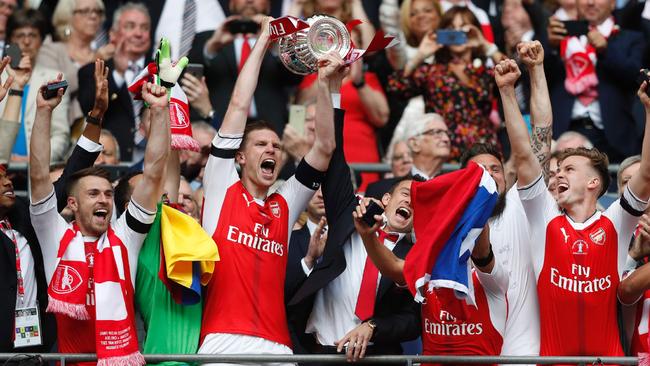 Arsenal's German defender Per Mertesacker lifts the FA Cup trophy.