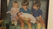 Baby Emma Louise Warland is held by her older siblings after being stillborn. Picture Supplied by family