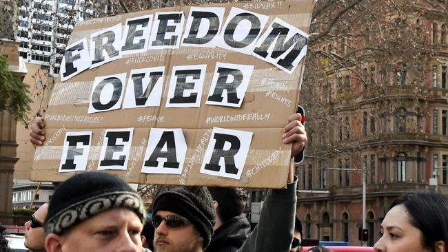 A man holds a placard during a mass protest in Sydney on Saturday. Picture: Matrix.