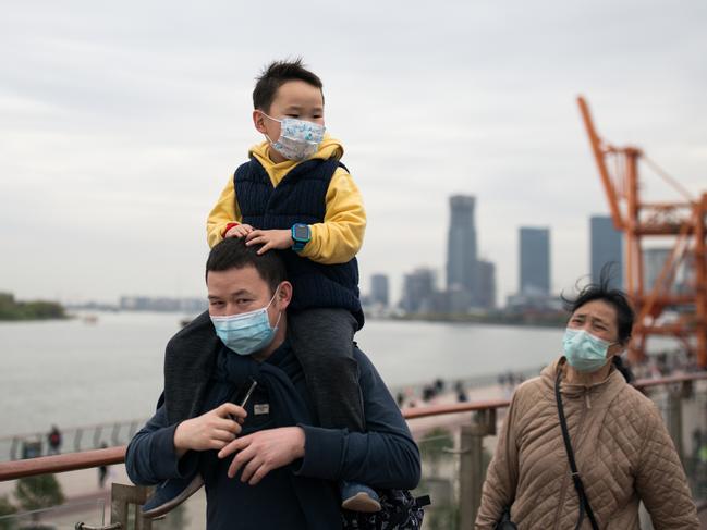 SHANGHAI, CHINA - APRIL 06: A family wear protective masks while walking in a city park on April 06, 2020 in Shanghai, China. Shanghai has reopened most of outdoor public facilities by the end of March. Health authorities of China said the country has passed the peak of the COVID-19 epidemic on March 12. As of today, the novel coronavirus (COVID-19) has infected more than 1,250,000 people and killed over 70,000 globally. The World Health Organization (WHO) declared the rapidly spreading coronavirus outbreak a pandemic on March 11. (Photo by Yves Dean/Getty Images)