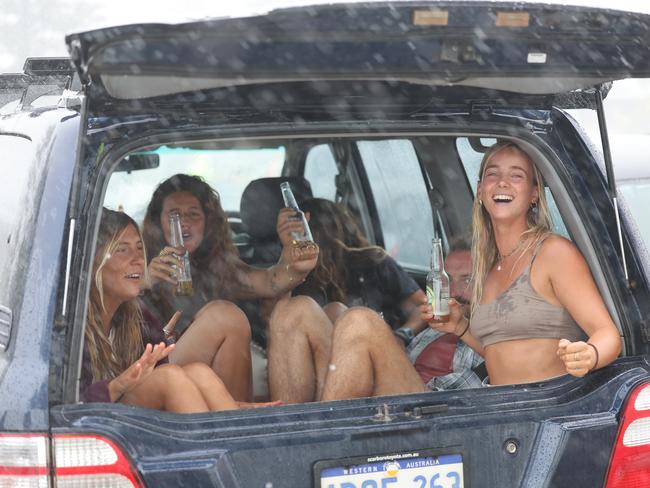 Party in the back of an SUV at Main Beach, Byron Bay. Getting one last surf in before Cyclone Alfred hits on Saturday. Picture: Rohan Kelly