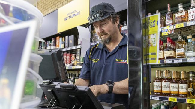 Mr Condo scans customers’ IDs into the Banned Drinkers Registers machine. Picture: Jon Gellweiler/news.com.au