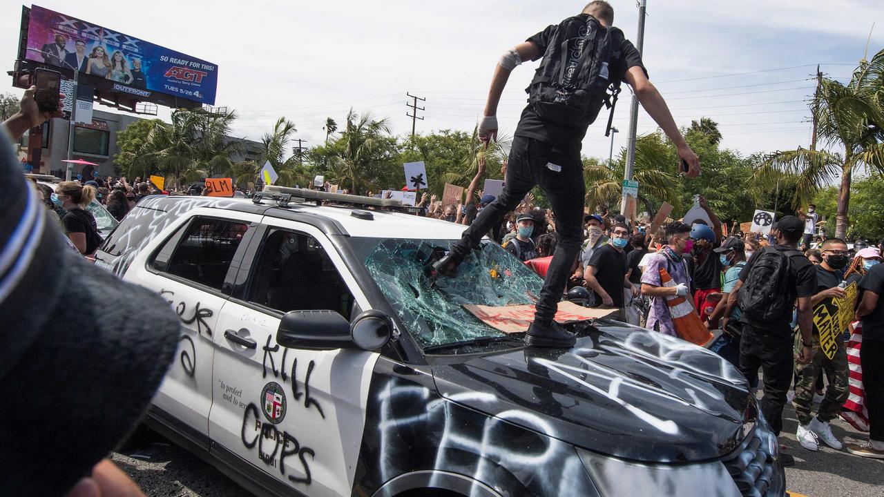 Demonstrators smash a police vehicle in the Fairfax District. Picture: AFP