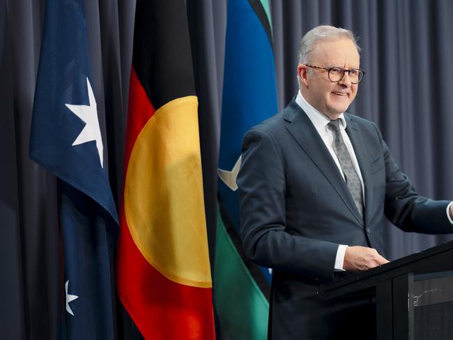 Prime Minister Anthony Albanese speaking before the Australian, Aboriginal and Torres Strait Islander flags. Picture: NewsWire/David Beach