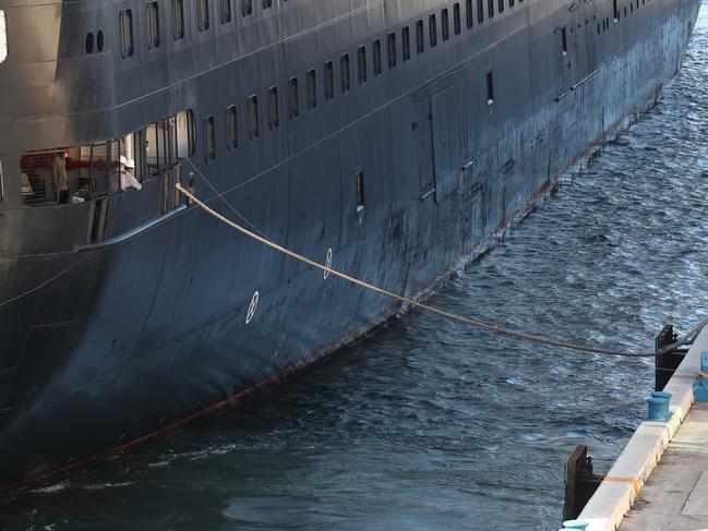 Workers are seen as they dock the Zaandam cruise ship at Port Everglades.