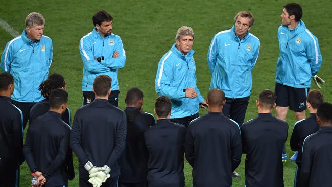 Manchester City coach Manuel Pellegrini (C) addresses the squad ahead of a team football training session at the International Champions Cup tournament in Melbourne on July 20, 2015. AFP PHOTO / Paul CROCK -- IMAGE RESTRICTED TO EDITORIAL USE - STRICTLY NO COMMERCIAL USE