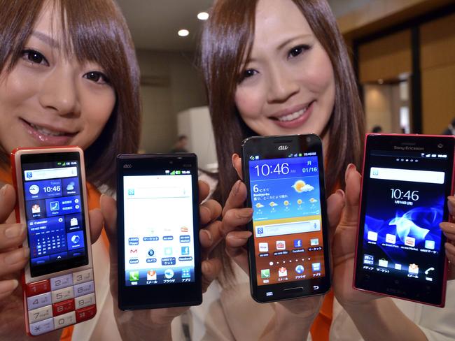 Models display Japan's second largest mobile phone carrier KDDI's smartphones (L-R) "Infobar", produced by Sharp, "Galaxy S II" by Samsung, "Optimus X" by LG Electronics and "Xperia acro HD" by Sony Ericsson in Tokyo on January 16, 2012.     AFP PHOTO / Yoshikazu TSUNO