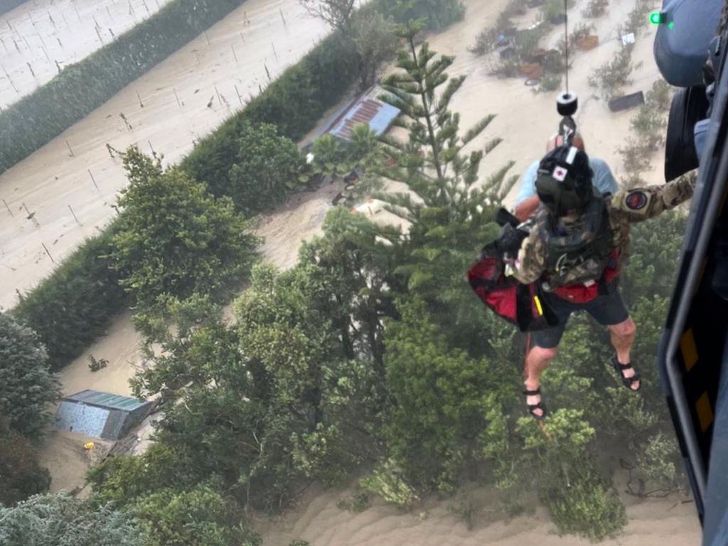 Stranded people being air lifted from their rooftop by a military helicopter in the Esk Valley, near the North Island city of Napier. Picture: AFP