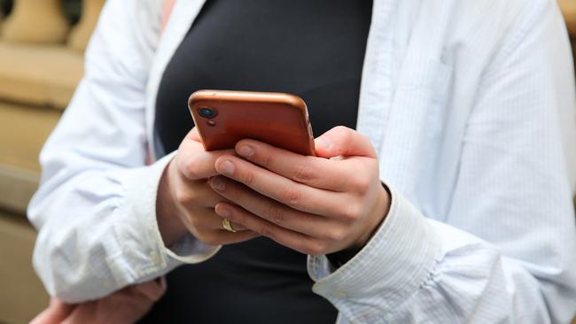 SYDNEY, AUSTRALIA - Newswire Photos - JULY 25 2023: People are seen on their mobile phones during lunch time in the Sydney CBD. Picture: NCA Newswire / Gaye Gerard