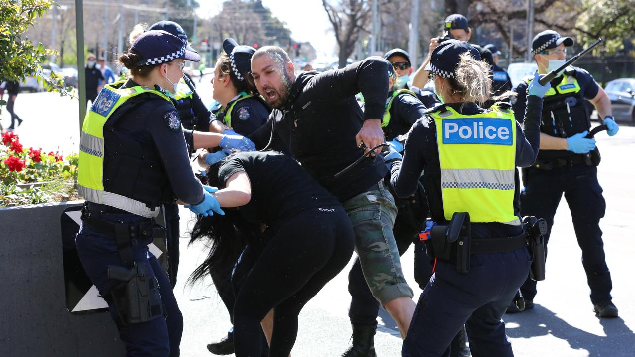 Police pictured amid violence on the streets of Melbourne during the wild lockdown protest.