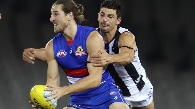 AFL Round 1. Western Bulldogs v Collingwood at Marvel Stadium..  21/03/2020.  Marcus Bontempelli of the Bulldogs looks to clear as Scott Pendlebury of the Magpies tackles   . Pic: Michael Klein