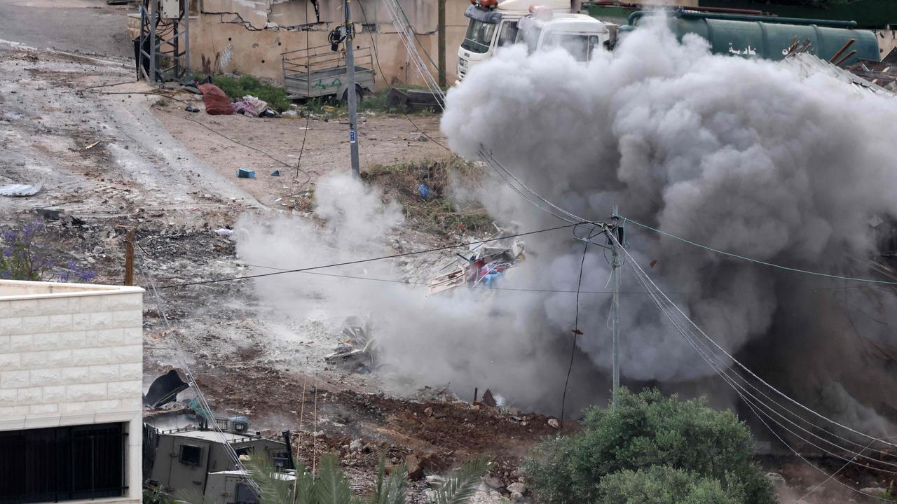 An explosion occurs in a building during a raid by Israeli troops in the occupied West Bank town of Deir al-Ghusun near Tulkarem on May 4. Picture: AFP