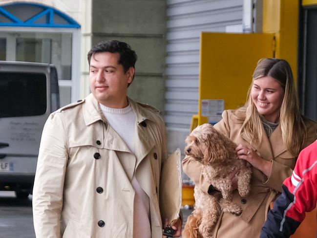 Brittany Higgins and David Sharaz cuddle their cavoodle dog Kingston and carry their cat Clover after the animals cleared quarantine at the Bordeaux-Merignac airport in France in December. Picture: Jacquelin Magnay