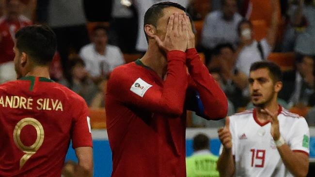 Portugal's forward Cristiano Ronaldo (C) reacts after missing a penalty.