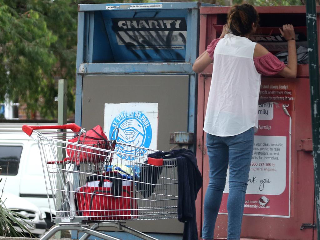 A woman goes through charity bins outside Northcott towers. Picture: John Grainger.