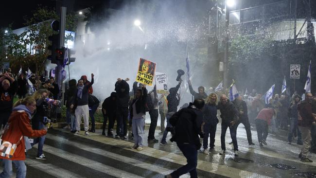 Protesters run as police officers use water cannons to disperse a demonstration against the Israeli Prime Minister Benjamin Netanyahu and calling for an hostages deal. Frustrations with the government have grown as over 100 hostages remain captive in Gaza, after more than four months of war between Israel and Hamas.