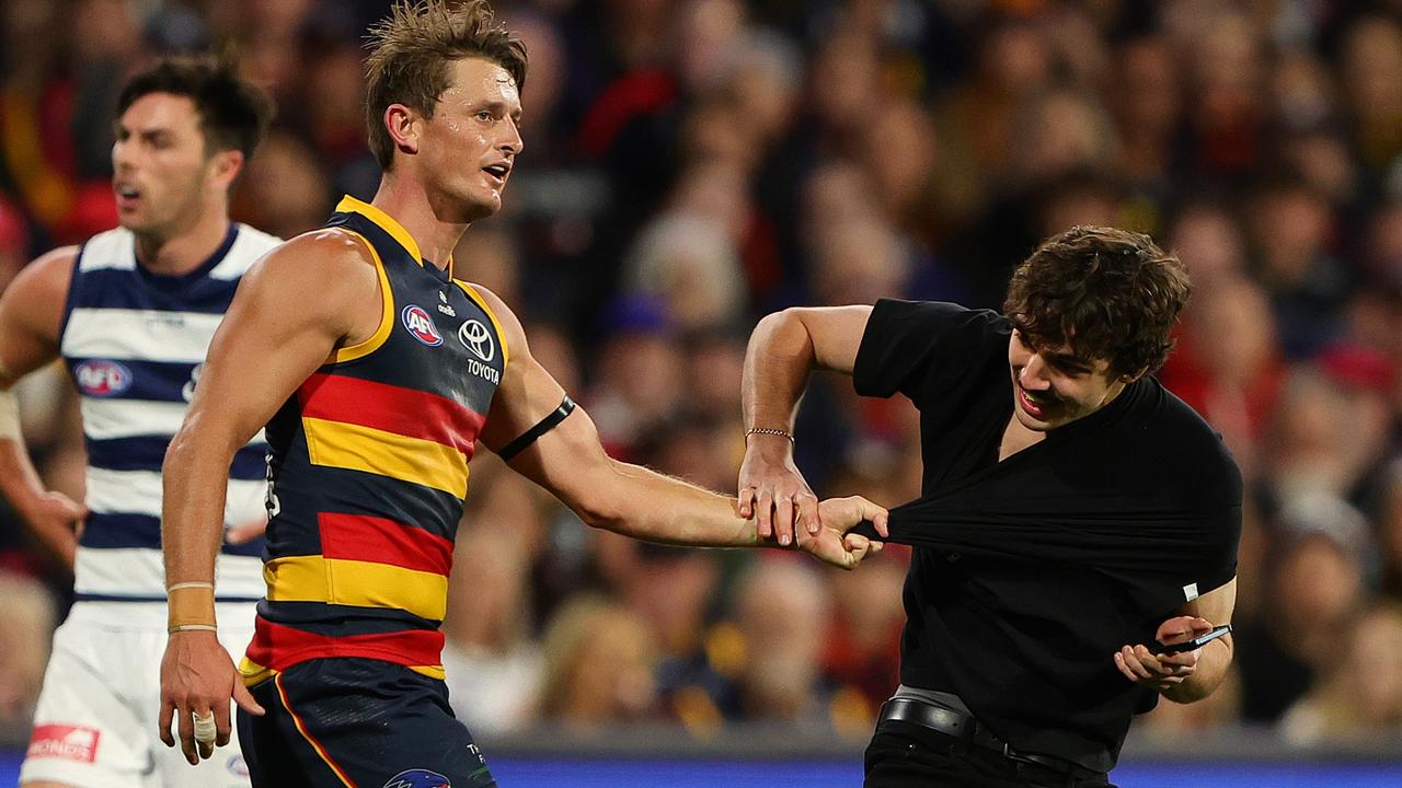 Adelaide’s Matt Crouch and pitch invader Julian Saginario. Picture: Sarah Reed/AFL Photos