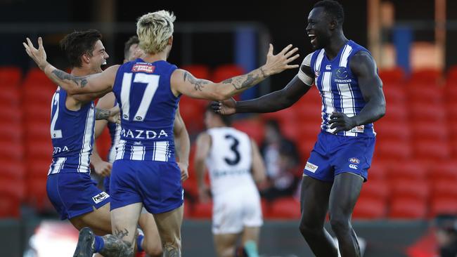 Majak’s Roo teammates get around him after his goal. Picture: Getty Images