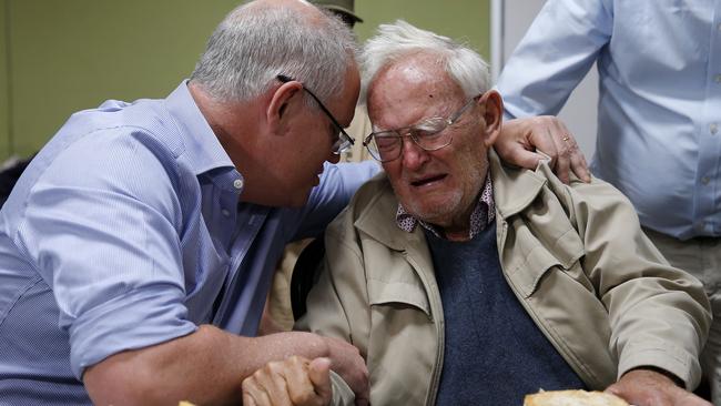 Prime Minister Scott Morrison comforts 85-year-old Owen Whalan who was evacuated from his home during a visit to Club Taree Evacuation Centre. Picture: AAP Image/Darren Pateman