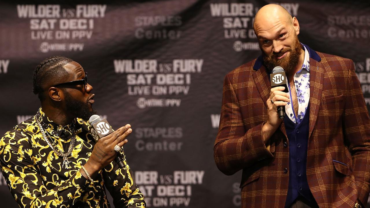 Deontay Wilder (L) and Tyson Fury speak during their press conference ahead of their fight on Sunday.