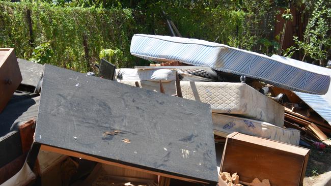 Streets in Machans Beach are piled high with wrecked furniture, whitegoods, mattresses and household contents as residents sort through what little is left. Picture: Bronwyn Farr