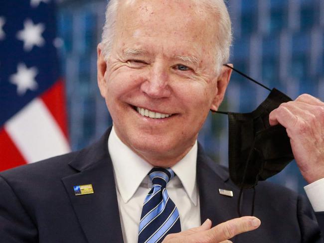 TOPSHOT - US President Joe Biden takes off his face mask he meets with NATO Secretary General during a NATO summit at the North Atlantic Treaty Organization (NATO) headquarters in Brussels on June 14, 2021. - The 30-nation alliance hopes to reaffirm its unity and discuss increasingly tense relations with China and Russia, as the organization pulls its troops out after 18 years in Afghanistan. (Photo by Stephanie LECOCQ / POOL / AFP)