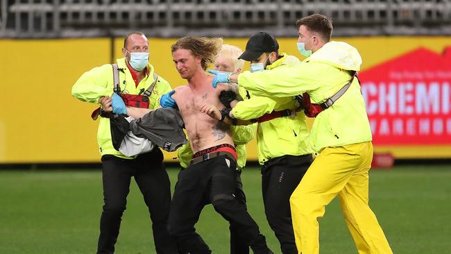 The pitch invader is escorted from the field. Picture: Getty