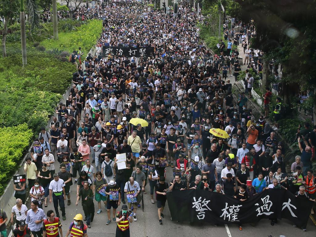 Protesters march with a banner that reads: "Police authority is too big" in Hong Kong. Picture: AP