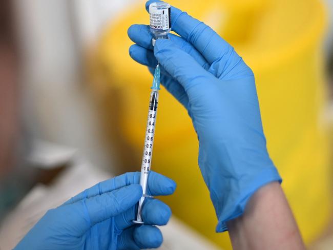 A clinician prepares a dose of a Pfizer Covid-19 vaccine at a temporary vaccination centre set up inside St John's Church in west London on December 4, 2021. - Britain, which has been among the hardest hit by Covid-19 with more than 145,000 deaths, is racing to offer third doses of coronavirus vaccines to all adults aged over 18 through its state-run National Health Service. (Photo by Daniel LEAL / AFP)