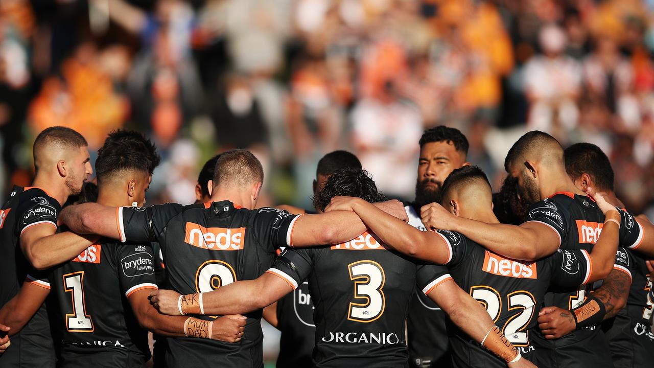 Tigers players wait in a huddle at Leichhardt Oval