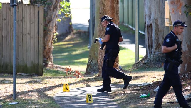 Police searching a laneway behind a unit where two men were stabbed. Photo: David Clark