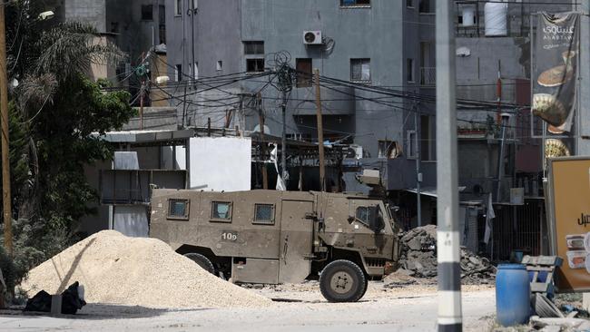 An Israeli military vehicle is stationed along a devastated street in the West Bank. Picture: AFP