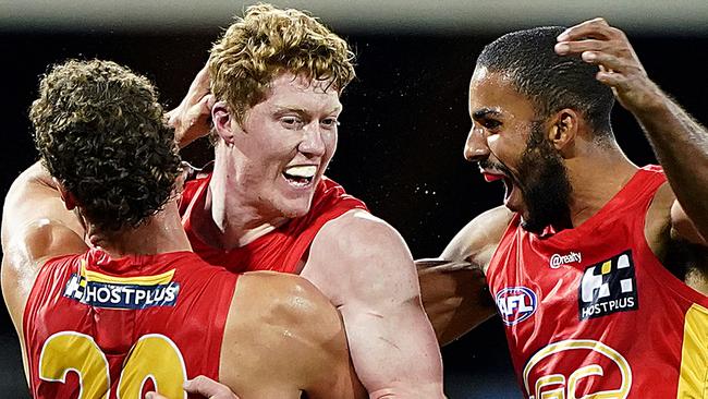 Suns players Jarrod Witts and Touk Miller (right) celebrate after Matthew Rowell (left) kicked a goal during the Round 4 AFL match between the Gold Coast Suns and the Fremantle Dockers at Metricon Stadium on the Gold Coast, Saturday, June 27, 2020. (AAP Image/Dave Hunt) NO ARCHIVING, EDITORIAL USE ONLY