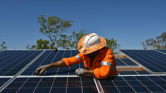 Northern Territory workers install solar panels in Daly River, Friday, August 11, 2017. Renewable energy has come to the Northern Territory bush, with solar power and battery storage set to provide an entire Aboriginal community?s daytime electricity needs for the first time. Around 500 residents from Daly River, more than 200km south of Darwin, will receive power entirely from the sun during the day when the solar and battery storage project is completed in September. (AAP Image/Lucy Hughes Jones) NO ARCHIVING