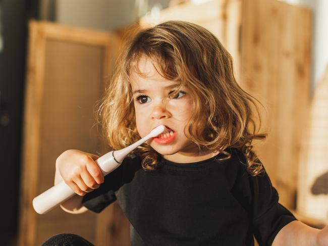 Boy brushing teeth in front of mirror