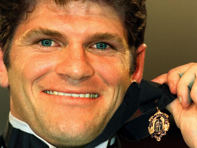 Footballer Robert Harvey holding 1998 Brownlow medal award. p/