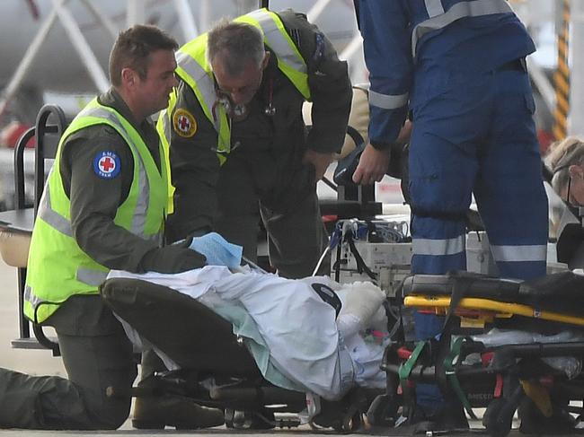 A survivor of the NZ volcano eruption is moved on to a stretcher at Sydney Airport. Picture: AAP