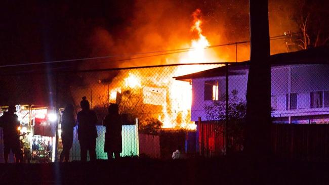 Neighbours watch helplessly as the house erupts in flames. Picture: Samantha Bean