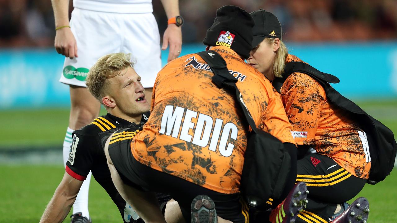 Chiefs star Damian McKenzie leaves the field injured during the match against the Blues.