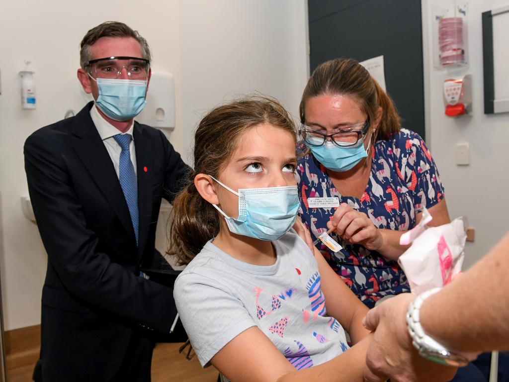 NSW Premier Dominic Perrottet watches on as Ines, 8, receives her first dose of the Covid-19 vaccine in Sydney. Picture: AAP Image/Bianca De Marchi