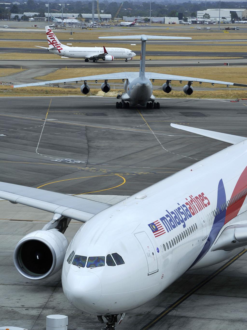 A Malaysian Airlines plane passes a Chinese Airforce Ilyushin II-76 at Perth Airport for search for missing Malaysian plane MH370.