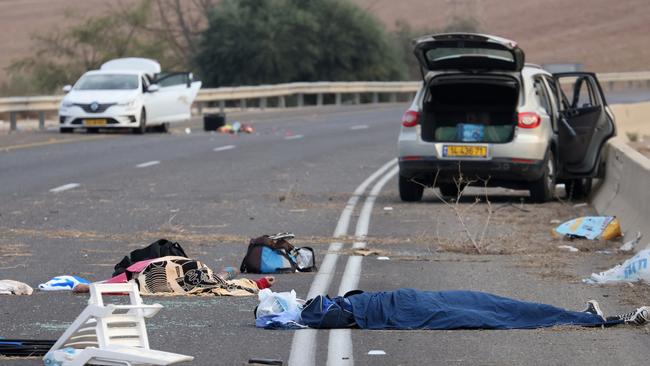 Bodies lie on a main road near the Gevim Kibbutz, close to the border with Gaza on October 7. Picture: AFP