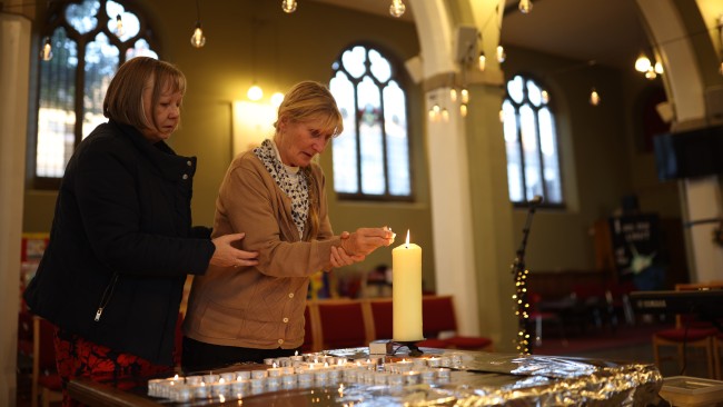 Constituent Ruth Verrinder and former councillor and mayor Judith McMahon (R) light a candle as they pay their respects at St Michael and All Angels Church, following the stabbing of UK Conservative MP Sir David Amess. Picture: Dan Kitwood/Getty Images