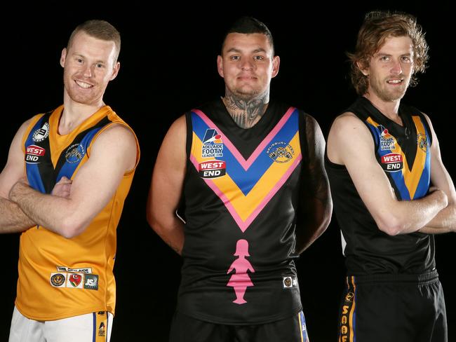 Salisbury West player DJ McIntyre (centre) models the club’s specially-designed guernsey with a touch of pink, alongside Daniel Mykytyschyn (left) and Justin Davies (right). Picture: AAP/Emma Brasier.